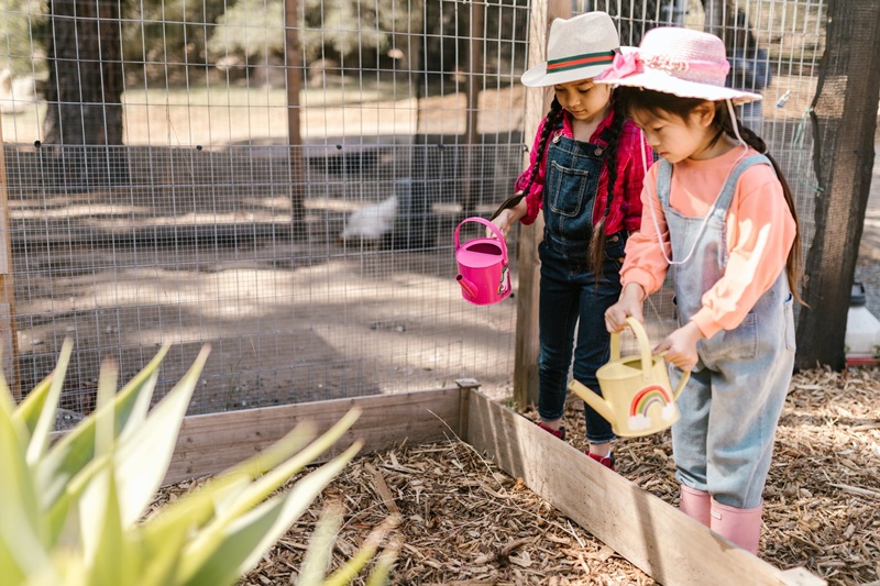 little kids watering plants